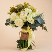 Golden Ivory Bloom bouquet with ivory roses, golden seasonal filler blooms, eucalyptus, jute wrap, and yellow ribbon by Rapid Petals by Yashken Fresh