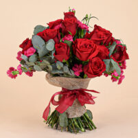 Ruby Pink Romance bouquet with red roses, pink carnation accents, eucalyptus, jute wrap, and deep red ribbon by Rapid Petals by Yashken Fresh